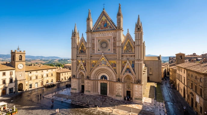 The magnificent golden facade of the Orvieto Cathedral, a masterpiece of Italian Gothic architecture in Umbria.